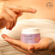 Serenade Barrier & Bliss Night Face Cream jar held by hands, with cream on fingertip.